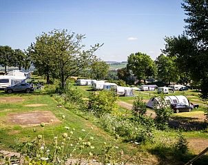 Camping site Comfort in Gulpen, South Limburg offers a beautiful view over green fields and caravans in a quiet nature campsite.